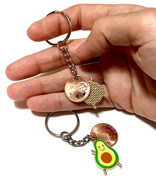 An avocado fruit lucky penny keychain with an engraved avocado above the date of a Lincoln Cent attached to an avocado charm.