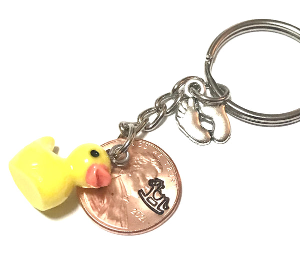 Silver Baby Feet and Yellow Duck Charms on a Lucky Penny Keychain with hand stamp engraved Rocking Horse design on a Lincoln Cent.