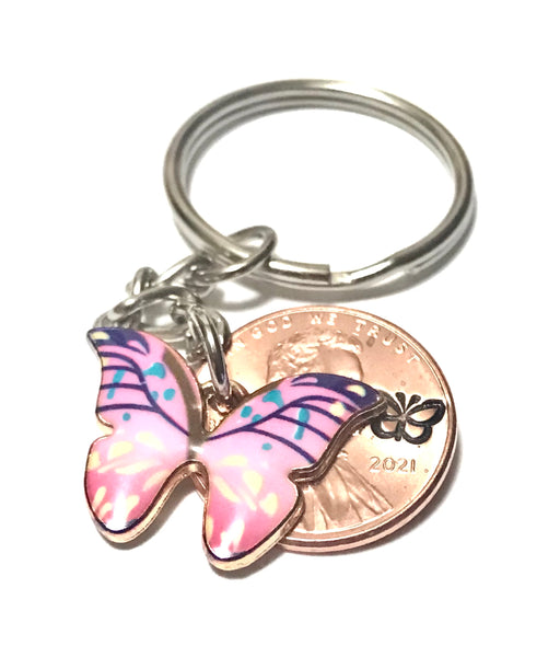 Light Pink Monarch Butterfly sized beside a Lincoln Cent showing the hand stamp butterfly engraving above the date.