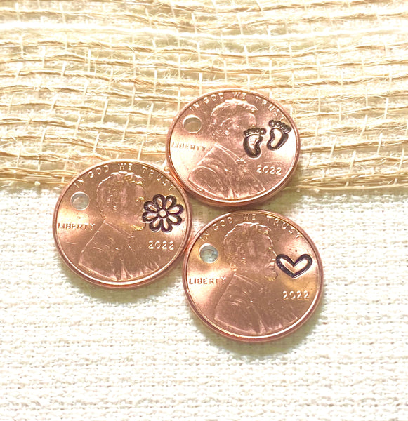 3 pennies hand stamped with your choice of footprints, a daisy flower, or a heart for love.