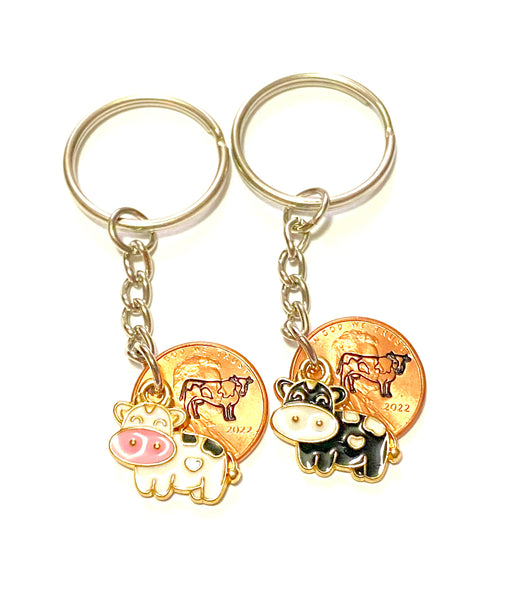 Detailed cow stamped pennies on 3" keychains with a white or black miniature cow charm.