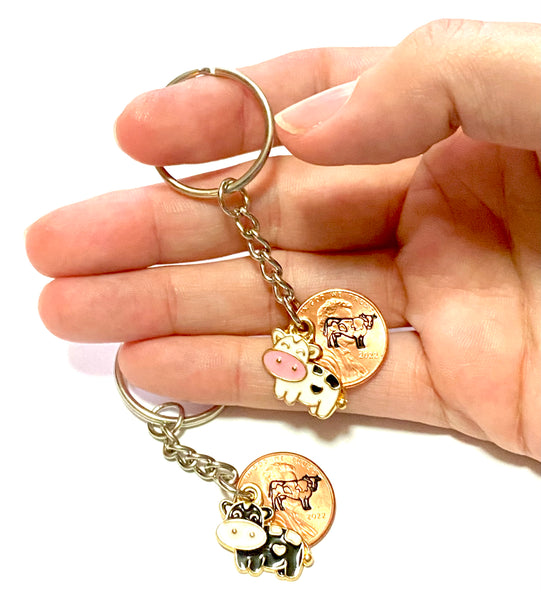 Mini Cow charms with a heart spot on the belly attached to a penny stamped with a detailed cattle design.