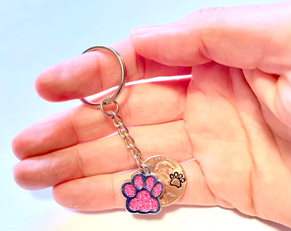 Pink Dog Paw Print Charm Lucky Penny Keychain with an engraved dog paw design above the date of a Lincoln Cent.