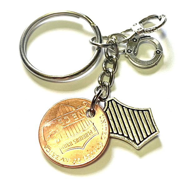 Police Department Lucky Penny Keychain with a silver shield charm and silver set of handcuffs along with an engraved shield with a star on a Lincoln Cent.