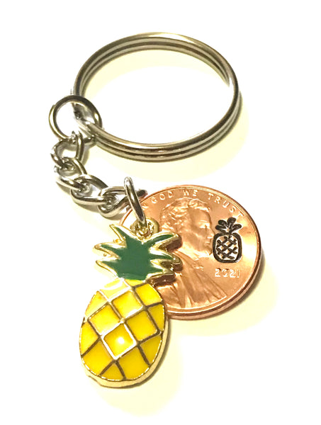 Pineapple Golden Fruit Charm Lucky Penny Keychain alongside a hand stamped Lincoln Cent with a Pineapple engraving above the date.