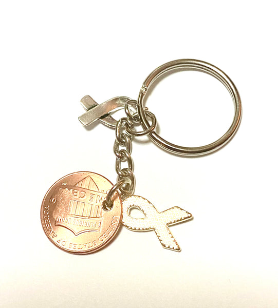 A green ribbon charm for mental health awareness month with a silver HOPE charm attached to a Lincoln Cent engraved with a detailed design of an awareness ribbon for a great Lucky Penny Keychain!