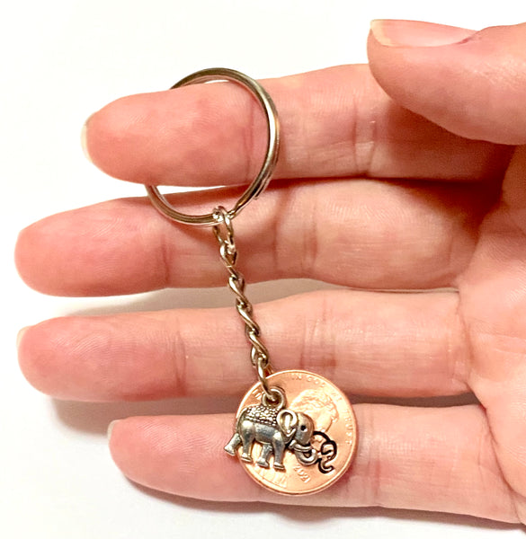 A Silver Elephant Charm attached to an engraved Lincoln Cent with a matching design above the date to make the perfect Lucky Penny Keychain.