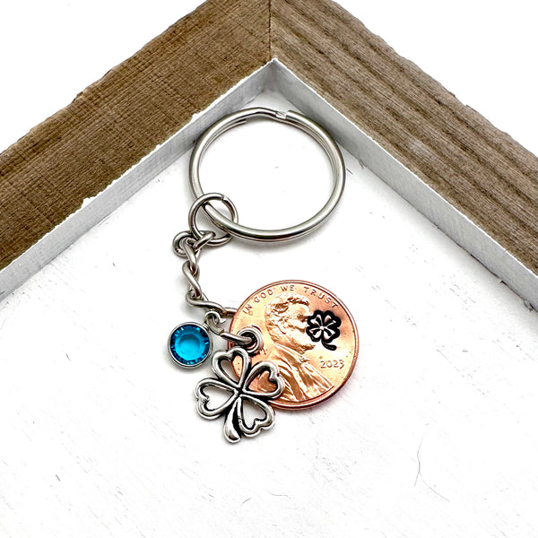 Hand stamped penny with clover design paired with a silver clover charm and birthstone.