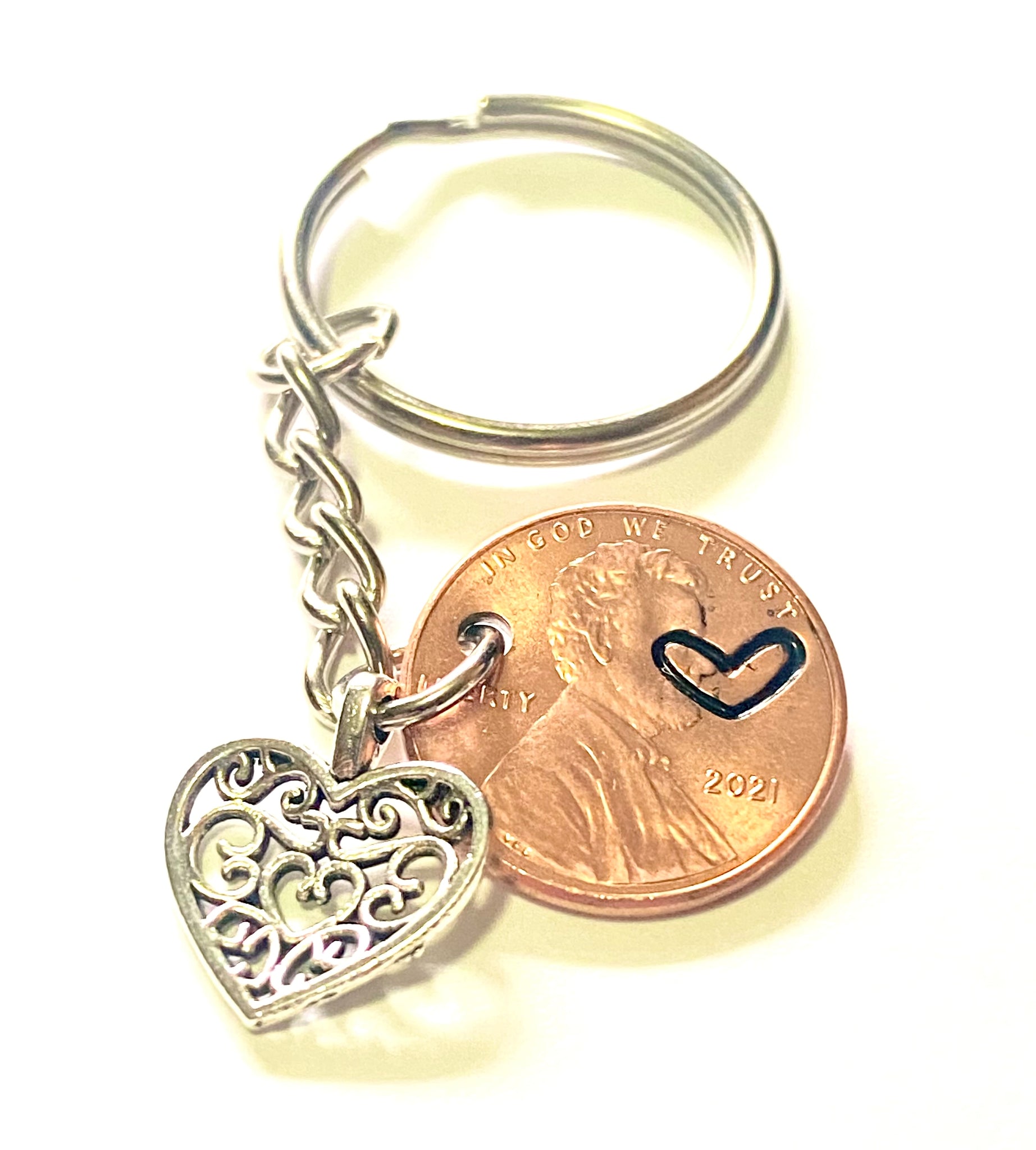 A lucky penny keychain with a silver heart charm.