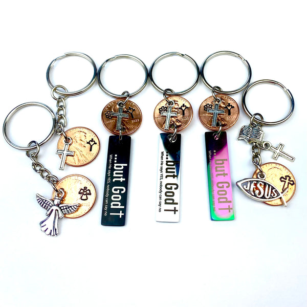 A collection of cross and angel charms and stamps as Lucky Penny Keychains by Palmetto Charms & Etc.