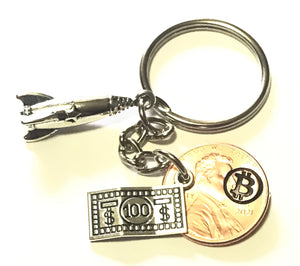 Bitcoin Logo engraved on a Lucky Penny Keychain with a silver 100 charm and a To The Moon Rocket charm.