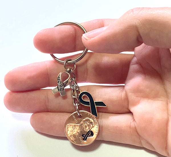 Skin Cancer Awareness Black Ribbon Charm with a silver HOPE charm with an engraved ribbon design on a Lincoln Cent to make a great Lucky Penny Keychain.