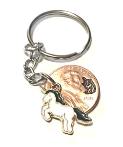 A Unicorn Lucky Penny Keychain with a Unicorn Charm with a Black Mane and Tail with a hand stamped design above the date of a Lincoln Cent.