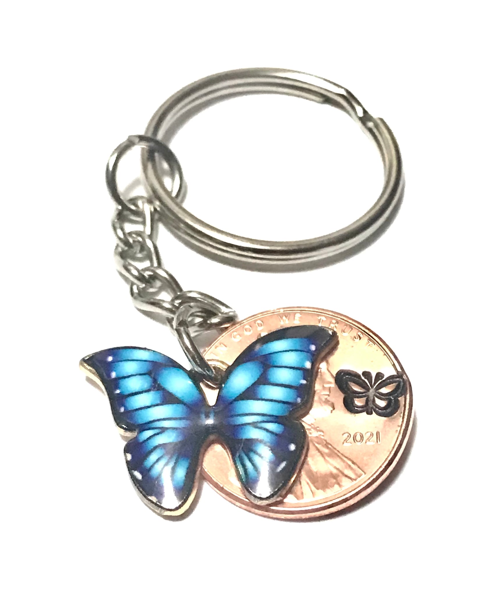 Blue Monarch Butterfly sized beside a Lincoln Cent  showing the hand stamp butterfly engraving above the date.