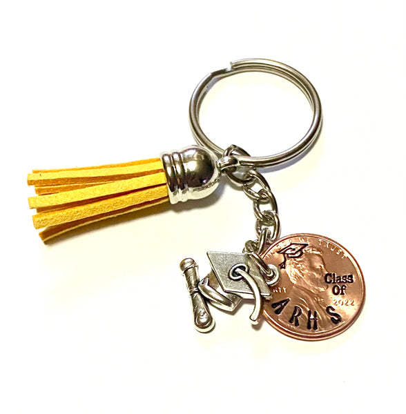 A hand stamped penny with a grad cap on Lincoln's head that matches the silver charm. Also, includes a yellow tassel.