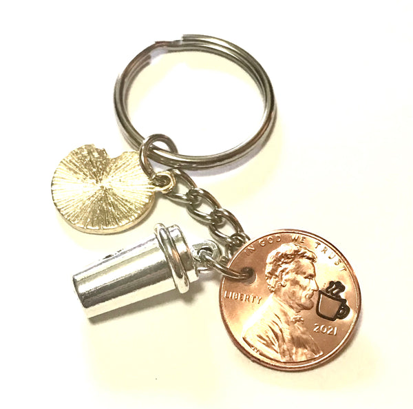 Lucky Penny Keychain with Pink Doughnut & silver Coffee Cup alongside an engraved Lincoln Cent showing a steaming cup of joe.