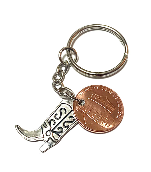 A Silver Cowgirl Boot charm attached to a Lincoln Cent with a cowgirl hat engraved above the date on this 3" Lucky Penny Keychain.