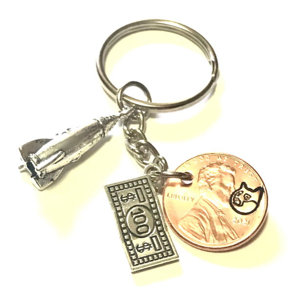 Dogecoin Logo engraved on a Lucky Penny Keychain with a silver 100 charm and a To The Moon Rocket charm.