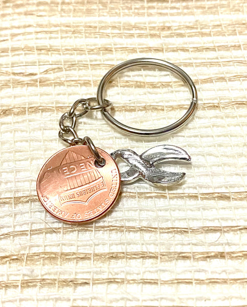 The rear view of our hand stamped Lucky Penny Keychains with a silver Down Syndrome charm on a 3" keychain.