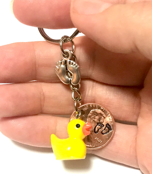 Silver Baby Feet and Yellow Duck Charms on a Lucky Penny Keychain with hand stamp engraved Baby Feet design on a Lincoln Cent.