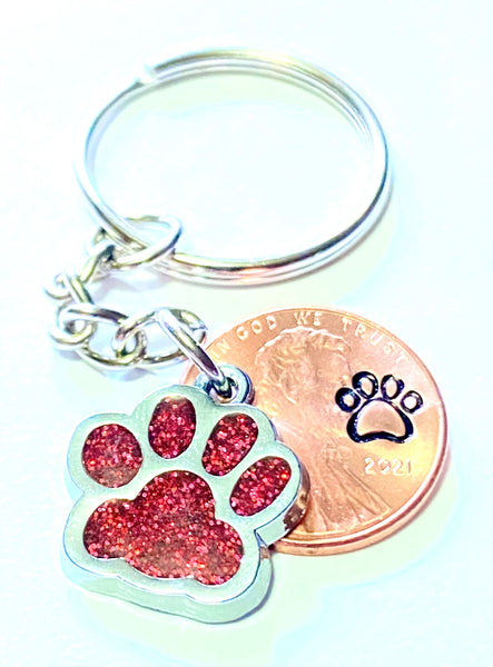 Red Dog Paw Print Charm Lucky Penny Keychain with an engraved dog paw design above the date of a Lincoln Cent.