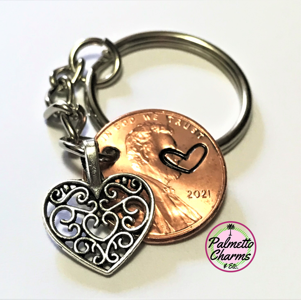 A Silver filigree heart charm keychain with a hand stamped Lincoln Cent.