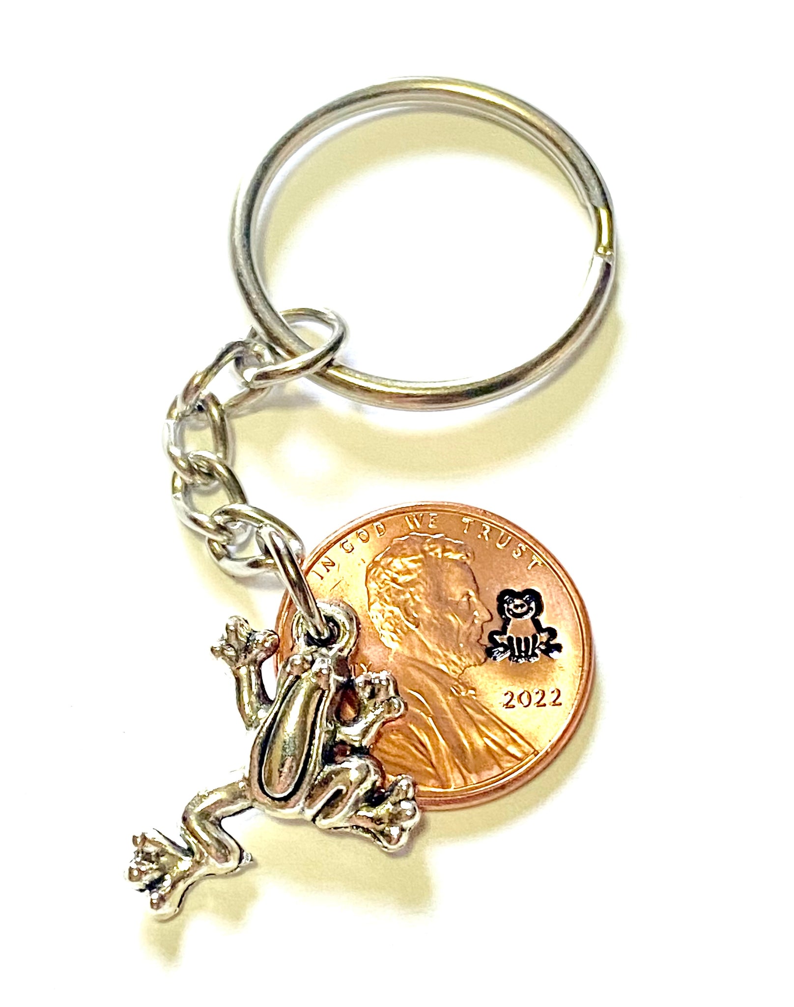 Frog Lucky Penny Keychain with a silver frog charm attached to a Lincoln Cent showing an engraving of a happy frog.