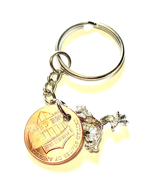 Frog Lucky Penny Keychain with a silver frog charm attached to a Lincoln Cent showing an engraving of a happy frog.
