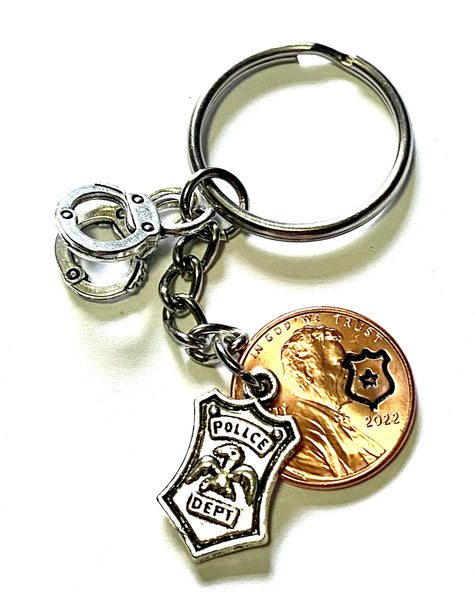 Police Department Lucky Penny Keychain with a silver shield charm and silver set of handcuffs along with an engraved shield with a star on a Lincoln Cent.