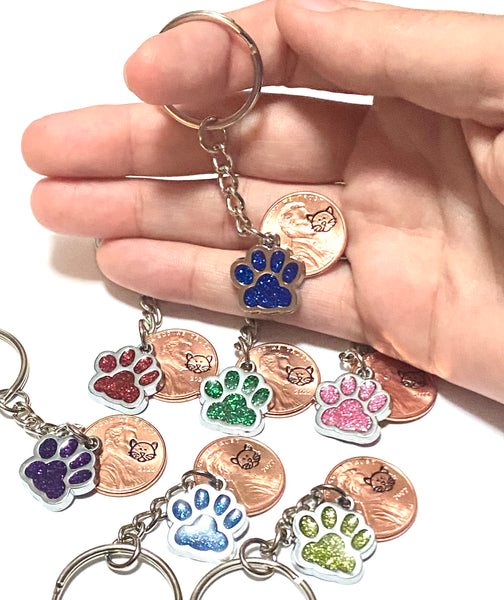 Full length 3" lucky penny keychains with cat face engravings on the penny and glitter charm cat paw prints.