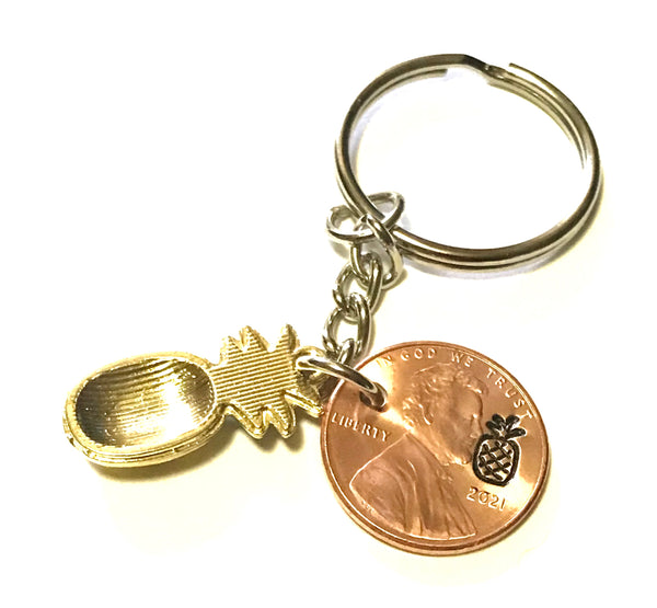 Pineapple Golden Fruit Charm Lucky Penny Keychain alongside a hand stamped Lincoln Cent with a Pineapple engraving above the date.