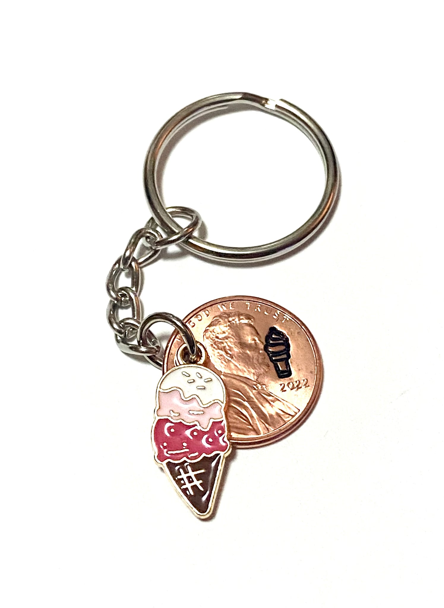 A Lucky Penny Keychain from Palmetto Charms with an enamel ice cream charm with a detailed design of an ice cream cone engraved above the date of a Lincoln Cent.