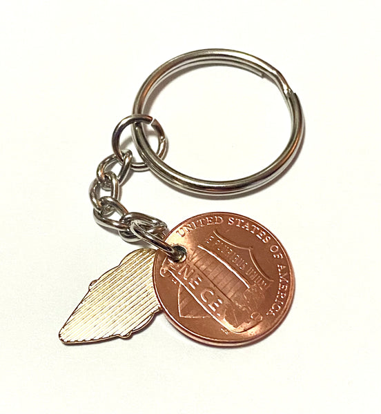A Lucky Penny Keychain from Palmetto Charms with an enamel ice cream charm with a detailed design of an ice cream cone engraved above the date of a Lincoln Cent.