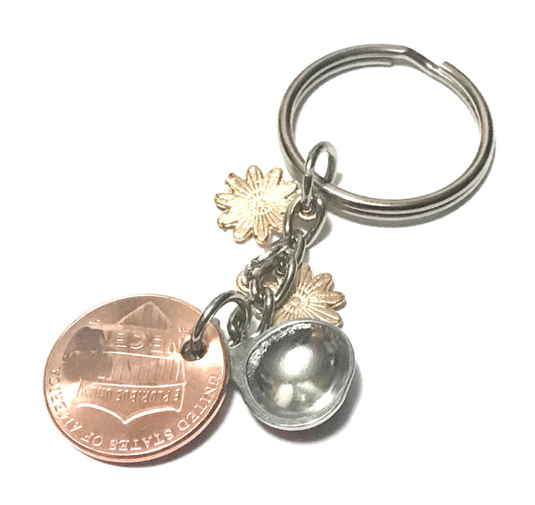 Ladybug and 2 white flower Charms with an engraved Ladybug above the date of a Lincoln Cent on this Lucky Penny Keychain.