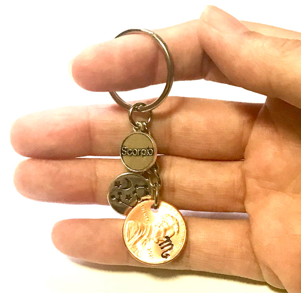 A Lucky Penny Keychain featuring the Scorpio Constellation and Zodiac symbol attached to a penny with a hand stamped Scorpio sign.
