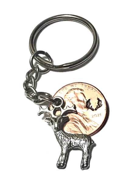 A Silver Deer Charm with an Antler Stamp engraved above the date of a Lincoln Cent to make a Lucky Penny Keychain.