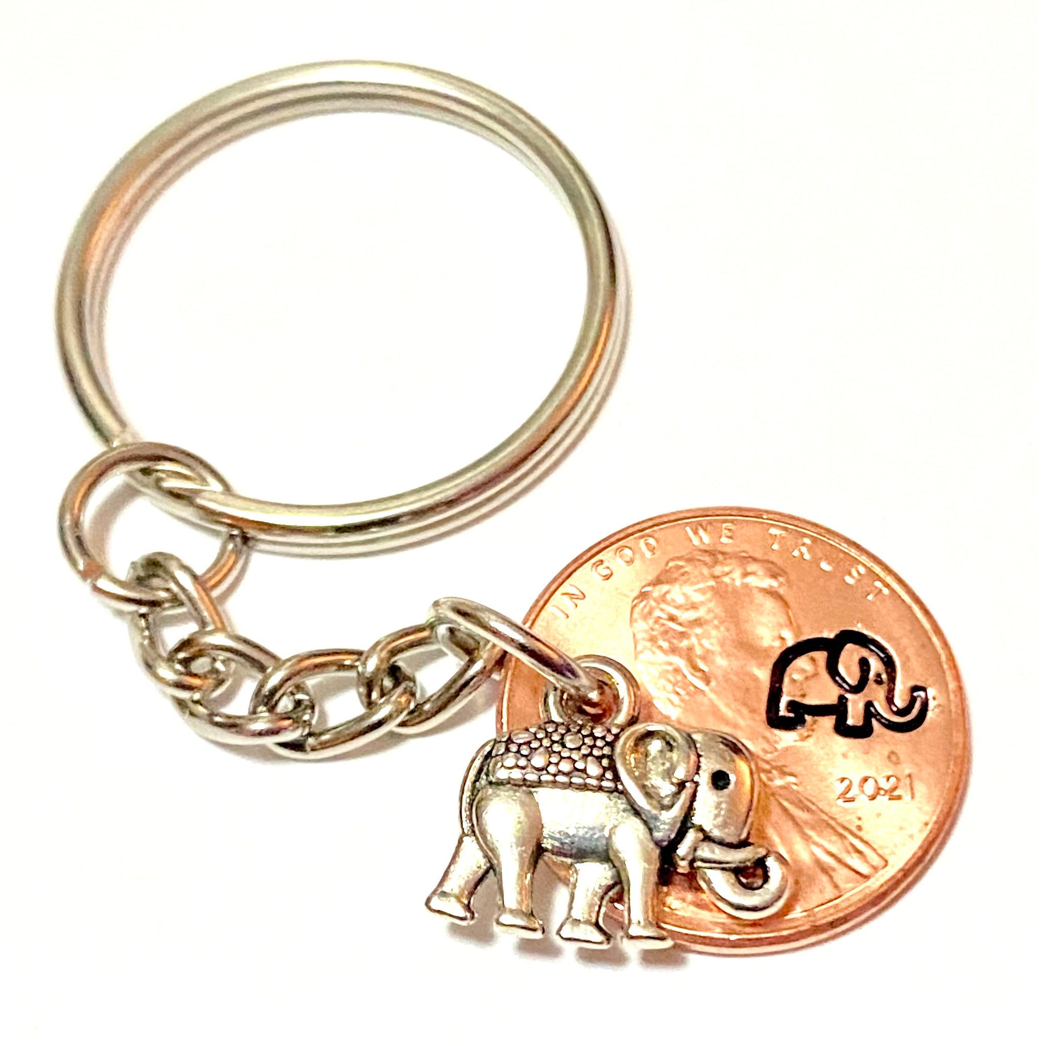 A Silver Elephant Charm attached to an engraved Lincoln Cent with a matching design above the date to make the perfect Lucky Penny Keychain.