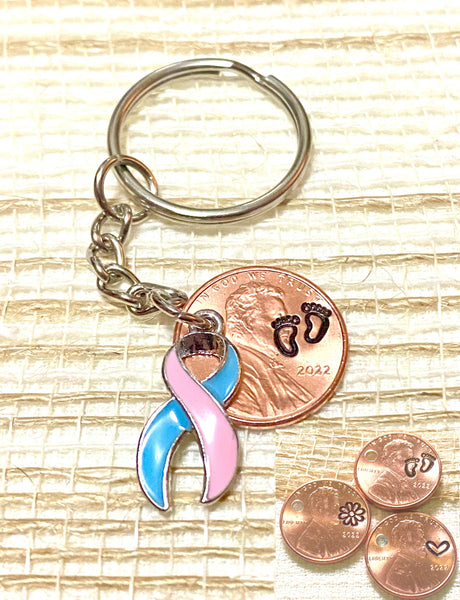 A pink and blue ribbon charm for raising awareness for infant loss, stillbirth, miscarriages. We attach this charm to an engraved penny.